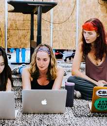 three students working together on the floor