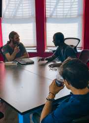 students conversing around a conference table